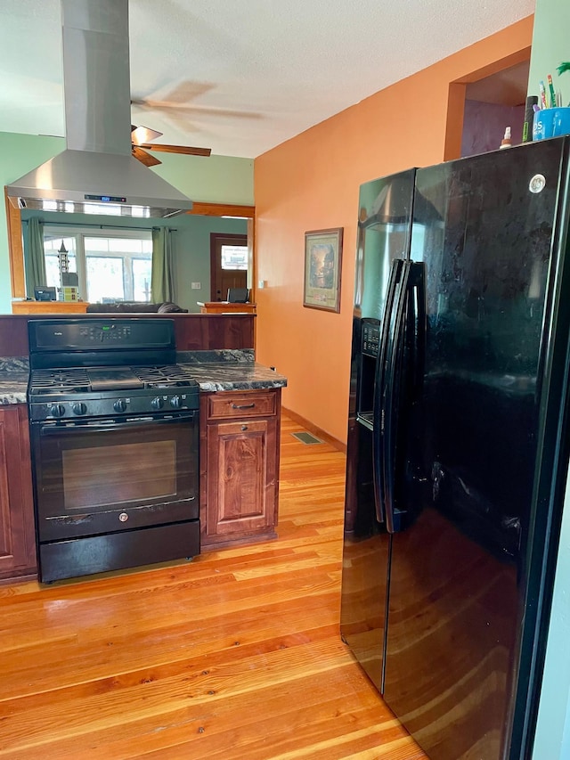 60 Main St, Kimball, MN 55353 - kitchen featuring black appliances, island exhaust hood, light wood-style floors, and a ceiling fan