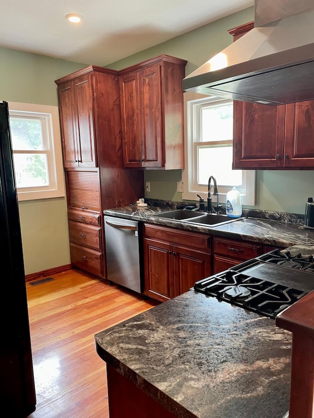 60 Main St, Kimball, MN 55353 - kitchen featuring dishwasher, wall chimney exhaust hood, dark countertops, light wood finished floors, and freestanding refrigerator