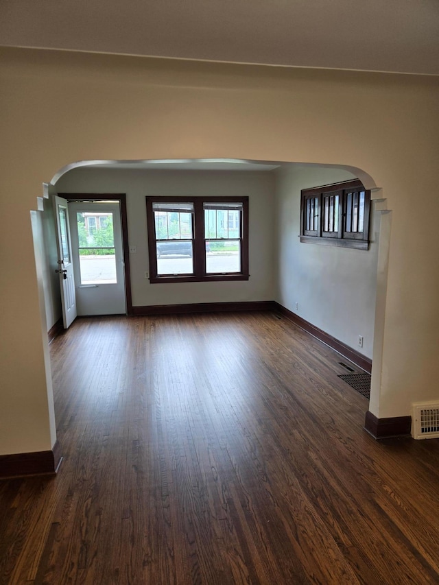 2742 Grand St NE, Minneapolis, MN 55418 - unfurnished room featuring arched walkways and dark wood-style flooring