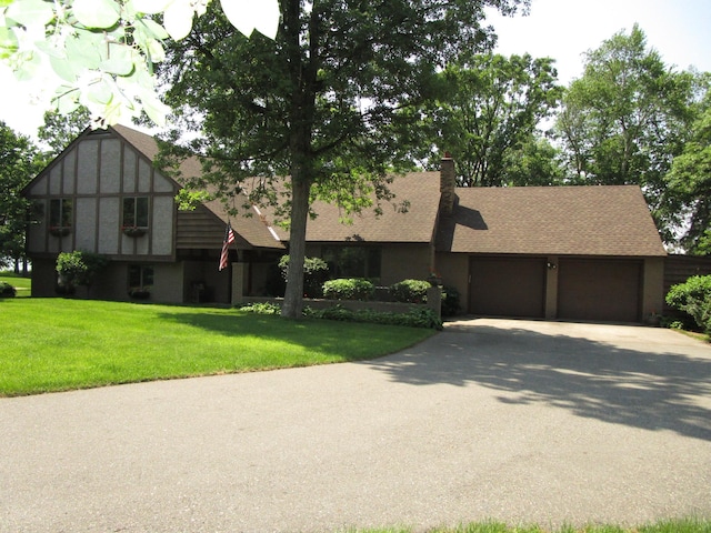 4523 Waville Rd NE, Bemidji, MN 56601 - view of front of home with asphalt driveway, an attached garage, a front lawn, a chimney, and roof with shingles