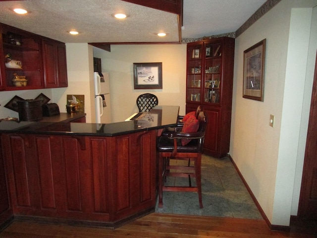 4523 Waville Rd NE, Bemidji, MN 56601 - bar with freestanding refrigerator, dark wood-style flooring, recessed lighting, and a textured ceiling