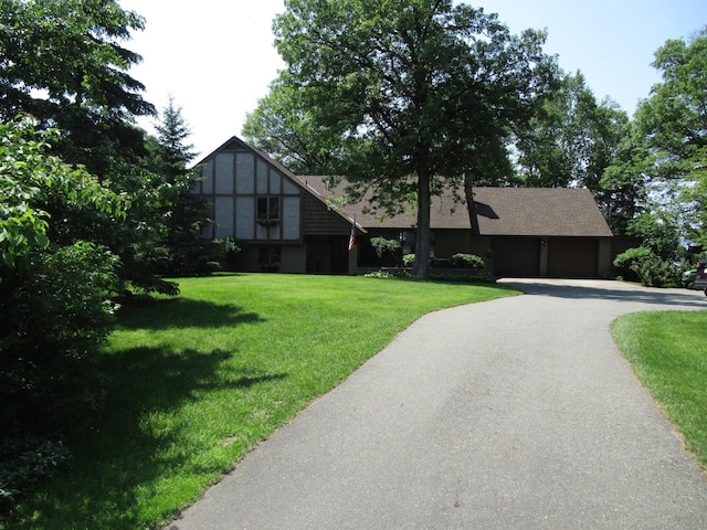 4523 Waville Rd NE, Bemidji, MN 56601 - tudor-style house featuring driveway, a front yard, and a shingled roof