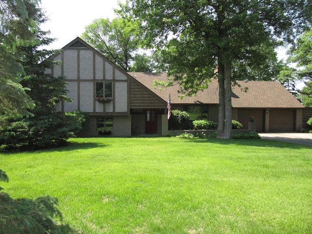 4523 Waville Rd NE, Bemidji, MN 56601 - tudor-style house with a front lawn, a garage, concrete driveway, and roof with shingles