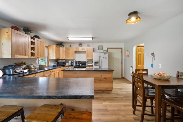 8241 120th St, Bogus Brook Twp, MN 56353 - kitchen featuring white refrigerator with ice dispenser, stainless steel microwave, dark countertops, light brown cabinets, and a peninsula