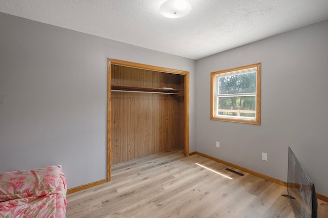 8241 120th St, Bogus Brook Twp, MN 56353 - unfurnished bedroom with wood finished floors, a closet, and a textured ceiling