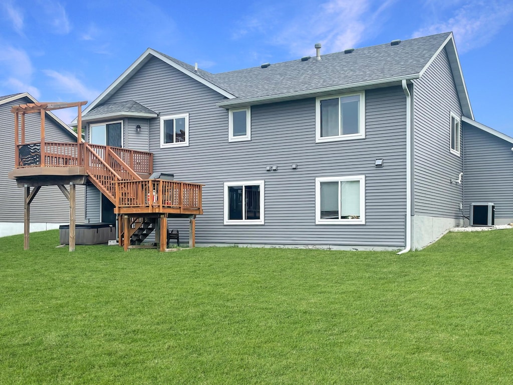 252 Birch St, Baldwin, WI 54002 - rear view of property featuring a hot tub, a deck, a yard, and a shingled roof