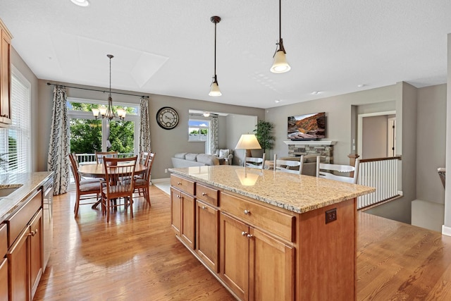 kitchen with light wood-type flooring, a chandelier, a center island, and decorative light fixtures