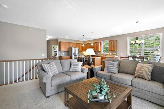 living area featuring a chandelier, recessed lighting, and light carpet