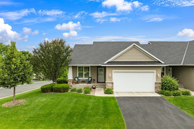 view of front of house with roof with shingles, asphalt driveway, a garage, and stone siding