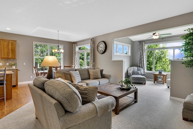 living room with a chandelier, plenty of natural light, ceiling fan, recessed lighting, and light colored carpet