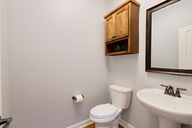 bathroom featuring baseboards and a sink