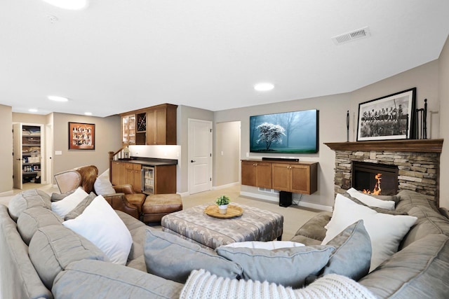 living area featuring light carpet, beverage cooler, a fireplace, and recessed lighting