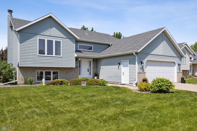 2819 33rd St S, Fargo, ND 58103 - split level home featuring a garage, a front lawn, brick siding, and concrete driveway