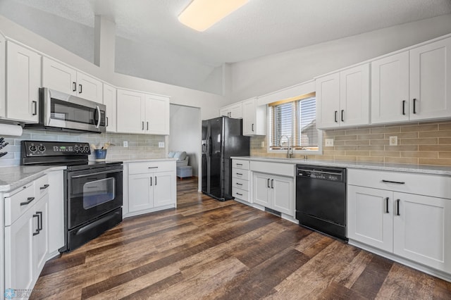 2819 33rd St S, Fargo, ND 58103 - kitchen with black appliances, lofted ceiling, dark wood-style flooring, tasteful backsplash, and white cabinets