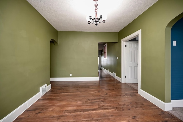 579 4th St, Winona, MN 55987 - unfurnished dining area with arched walkways, a textured ceiling, wood finished floors, and a chandelier