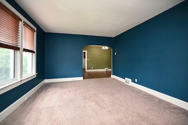 579 4th St, Winona, MN 55987 - carpeted empty room featuring arched walkways and a textured ceiling