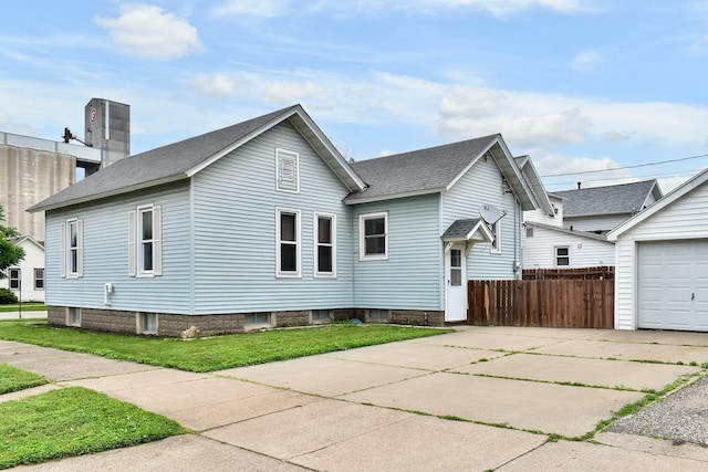 579 4th St, Winona, MN 55987 - rear view of house with concrete driveway, a shingled roof, and a garage