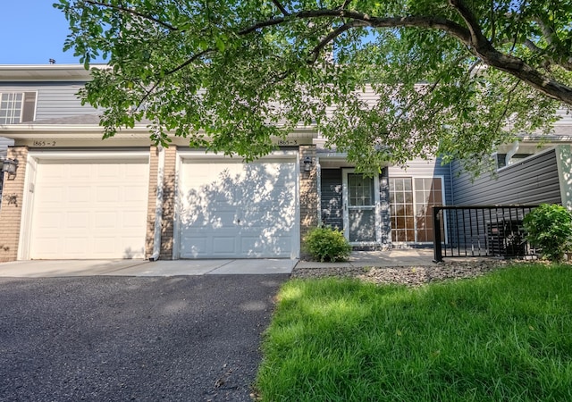 1865 Donegal Dr Unit 3, Woodbury, MN 55125 - obstructed view of property with driveway, brick siding, and a garage
