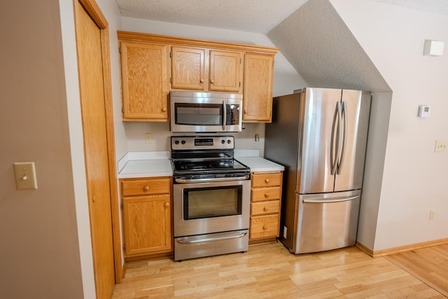 1865 Donegal Dr Unit 3, Woodbury, MN 55125 - kitchen with stainless steel appliances, light countertops, light wood finished floors, and a textured ceiling