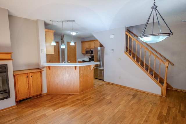 1865 Donegal Dr Unit 3, Woodbury, MN 55125 - kitchen with appliances with stainless steel finishes, a peninsula, light wood finished floors, and pendant lighting