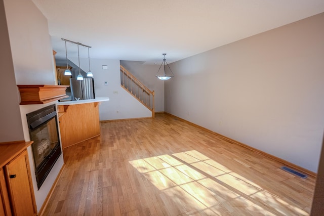 1865 Donegal Dr Unit 3, Woodbury, MN 55125 - unfurnished living room with light wood-type flooring, stairs, and a fireplace