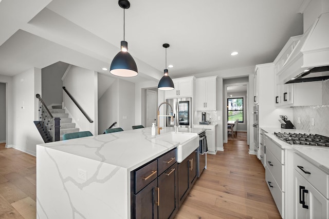 4805 Comstock Ln N, Plymouth, MN 55446 - kitchen with custom range hood, light wood-type flooring, white cabinets, recessed lighting, and stainless steel appliances