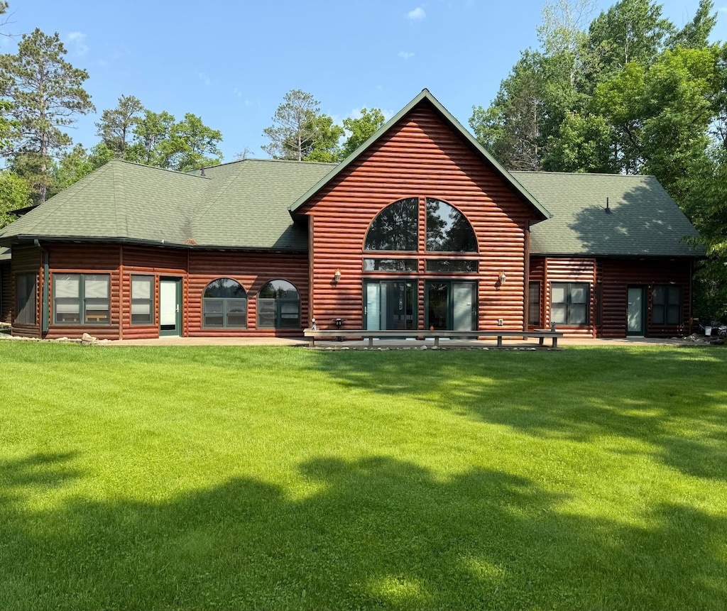 53245 Sunrise Ln, Savannah Twp, MN 56470 - rear view of house featuring a shingled roof, a lawn, and faux log siding
