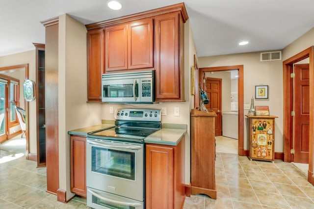 53245 Sunrise Ln, Park Rapids, MN 56470 - kitchen featuring stainless steel appliances, recessed lighting, light tile patterned floors, and brown cabinetry
