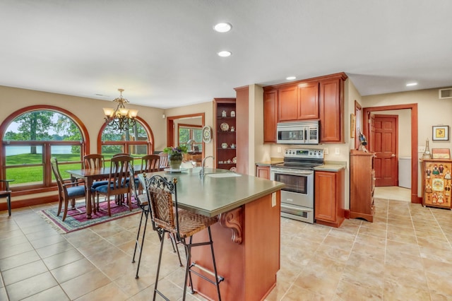 53245 Sunrise Ln, Park Rapids, MN 56470 - kitchen featuring stainless steel appliances, recessed lighting, a chandelier, a kitchen bar, and brown cabinetry
