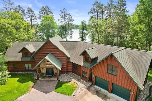 53245 Sunrise Ln, Park Rapids, MN 56470 - view of front of house with an attached garage, concrete driveway, a front lawn, a water view, and view of wooded area