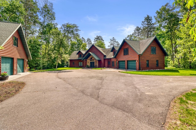 53245 Sunrise Ln, Park Rapids, MN 56470 - view of front of property with a garage, asphalt driveway, log veneer siding, a shingled roof, and a front lawn