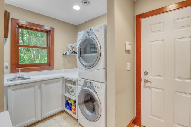 53245 Sunrise Ln, Park Rapids, MN 56470 - washroom featuring stacked washer / drying machine, light tile patterned floors, and cabinet space