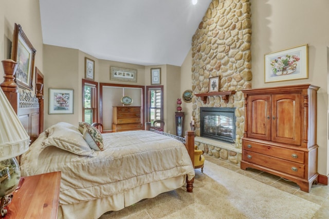 53245 Sunrise Ln, Park Rapids, MN 56470 - bedroom featuring light tile patterned floors, vaulted ceiling, and a stone fireplace