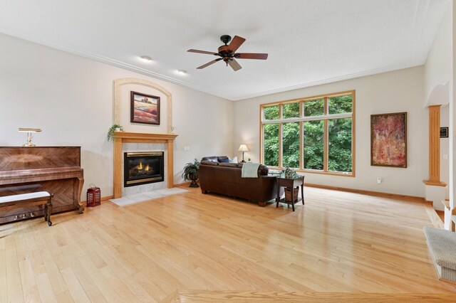 9534 Kirkwood Way N, Maple Grove, MN 55369 - living room with a tiled fireplace, a ceiling fan, light wood finished floors, and crown molding