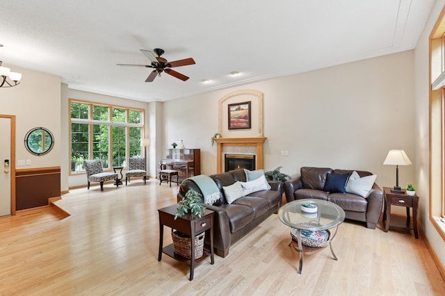 9534 Kirkwood Way N, Maple Grove, MN 55369 - living area with light wood finished floors, a ceiling fan, a glass covered fireplace, and ornamental molding
