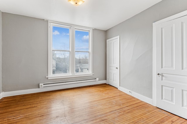 65 George St E, Saint Paul, MN 55107 - unfurnished bedroom featuring a baseboard radiator and light wood-style flooring