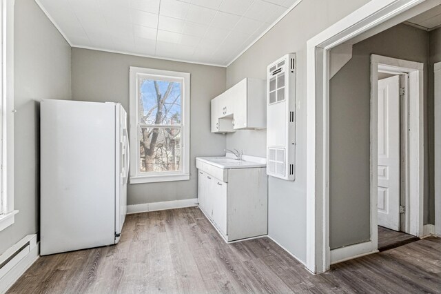 65 George St E, Saint Paul, MN 55107 - laundry room with a baseboard radiator, light wood-style floors, and crown molding