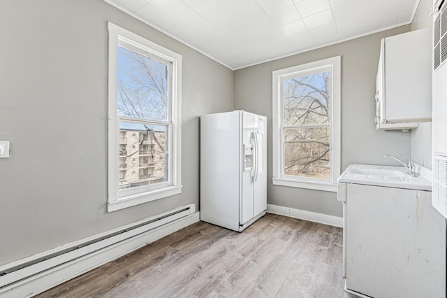 65 George St E, Saint Paul, MN 55107 - laundry area with baseboard heating, light wood-type flooring, healthy amount of natural light, and ornamental molding