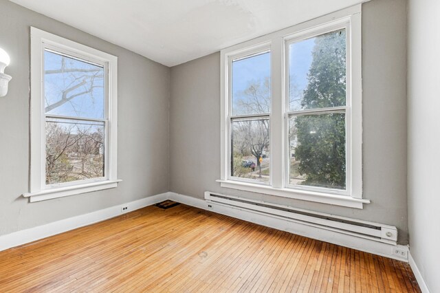 65 George St E, Saint Paul, MN 55107 - unfurnished room featuring a baseboard radiator, healthy amount of natural light, and hardwood / wood-style floors