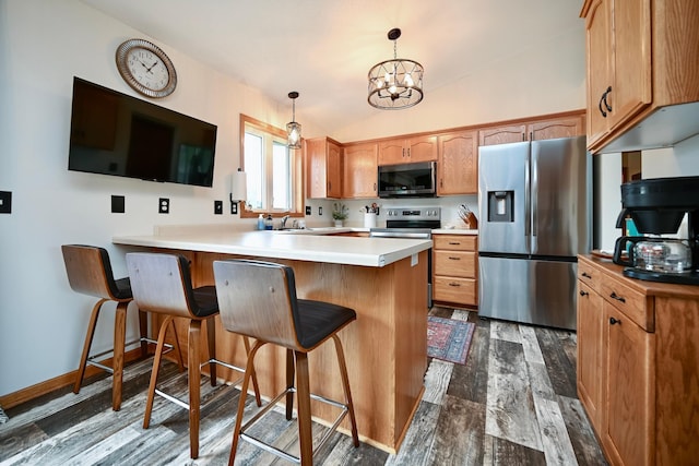 404 3rd Way SE, Dover, MN 55929 - kitchen featuring stainless steel appliances, a peninsula, dark wood-style flooring, a chandelier, and a breakfast bar area