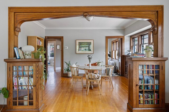 5000 Newton Ave S, Minneapolis, MN 55419 - dining area featuring light wood finished floors, radiator heating unit, arched walkways, and ornamental molding