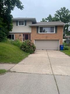 2243 Edgebrook Ave, Saint Paul, MN 55119 - split level home with a garage, concrete driveway, a front yard, and brick siding
