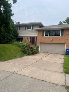 2243 Edgebrook Ave, Saint Paul, MN 55119 - tri-level home with an attached garage, brick siding, concrete driveway, and a front lawn