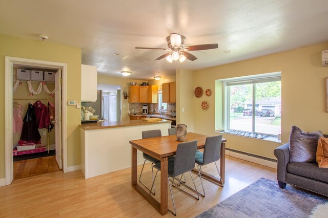 724 10th St NW, Bemidji, MN 56601 - dining space featuring a baseboard heating unit, light wood-type flooring, and a ceiling fan