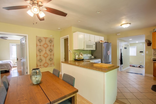 724 10th St NW, Bemidji, MN 56601 - kitchen with white appliances, ceiling fan, a peninsula, white cabinets, and recessed lighting