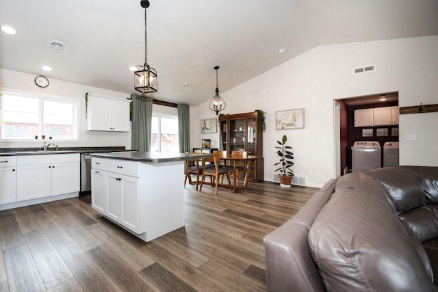 713 Prairie Wind Ave, Callaway, MN 56521 - kitchen with washer and dryer, open floor plan, dark countertops, vaulted ceiling, and dark wood-style floors