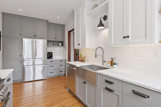 436 Holly Ave Unit 3, Saint Paul, MN 55102 - kitchen featuring stainless steel appliances, open shelves, gray cabinetry, decorative backsplash, and light stone counters