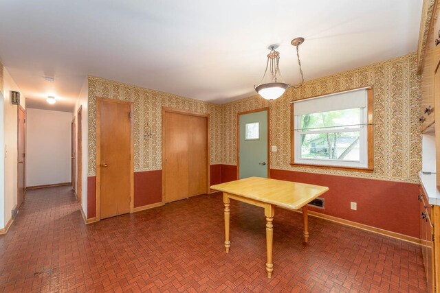 419 Jackson St, Saint Peter, MN 56082 - unfurnished dining area featuring wallpapered walls and brick patterned floors