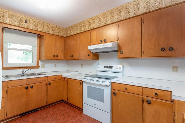 419 Jackson St, Saint Peter, MN 56082 - kitchen with white electric range, under cabinet range hood, light countertops, and brown cabinetry