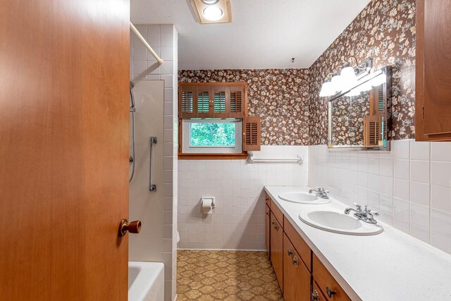 419 Jackson St, Saint Peter, MN 56082 - full bath with wallpapered walls, double vanity, a wainscoted wall, tub / shower combination, and tile walls